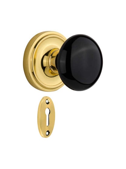 Classic Rosette Mortise-Lock Set with Black Porcelain Knobs in Polished Brass.